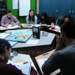 students sitting around a map of the world