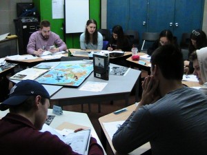 students sitting around a map of the world