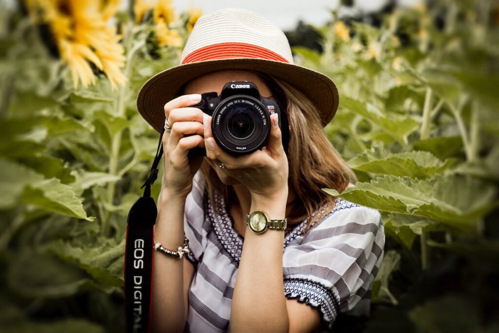 woman holding camera over her face